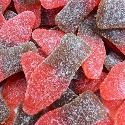 A close-up of Elevate Sour Cherry Bottles, cannabis-infused gummies shaped like mini soda bottles, with a vibrant red hue and a sugar-coated texture.