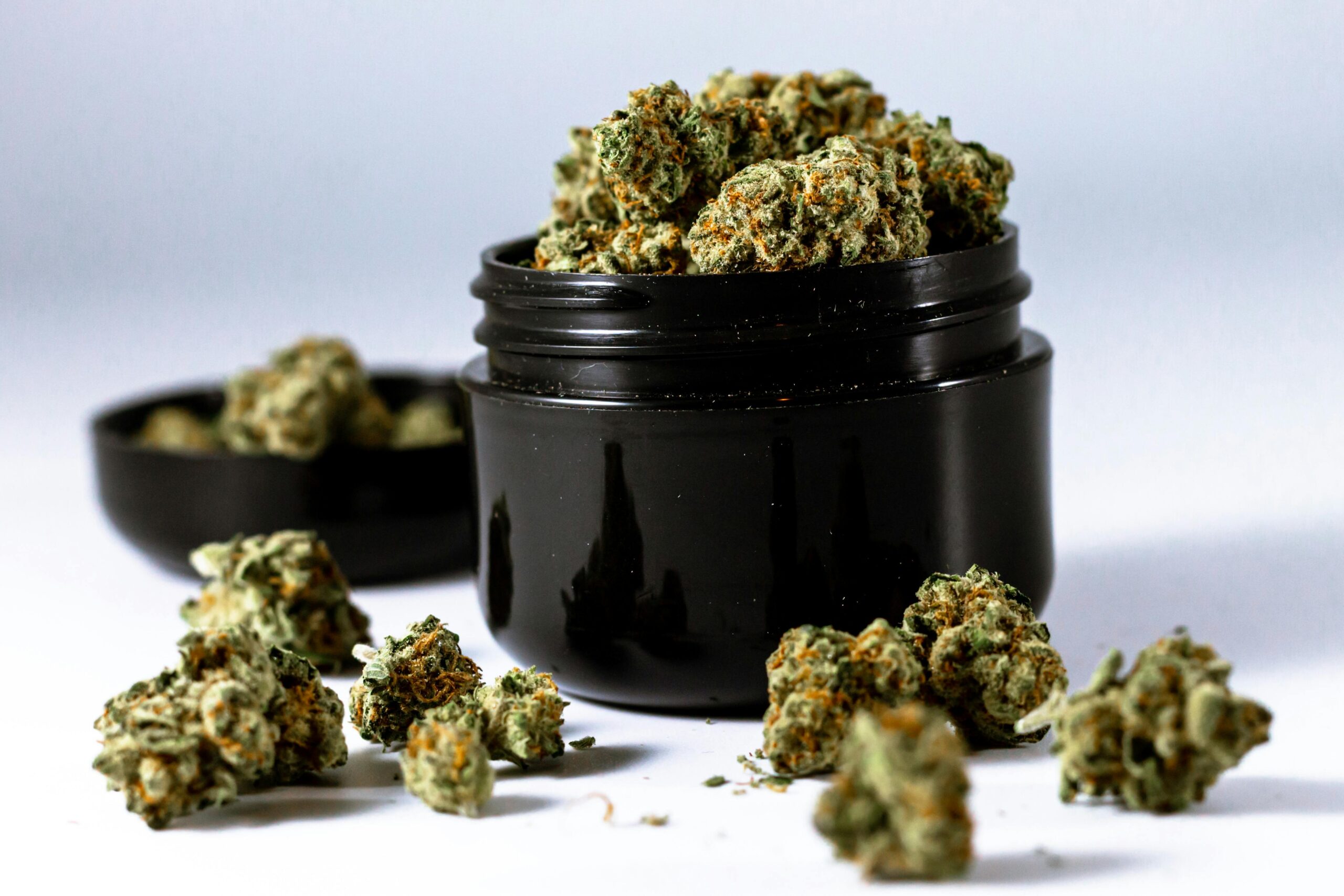Black jar filled with cannabis buds for weed delivery"