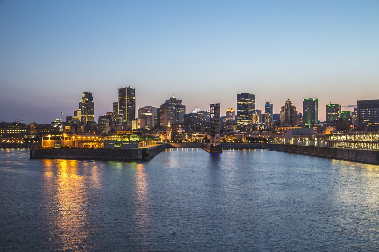 Montreal skyline at dusk with city lights reflecting on the water, a hotspot for cannabis delivery and weed delivery services.