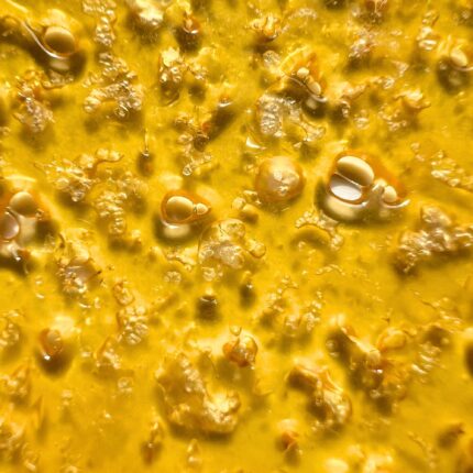 A close-up of Pink Rockstar shatter with a glossy, amber appearance, showcasing its high-quality texture.