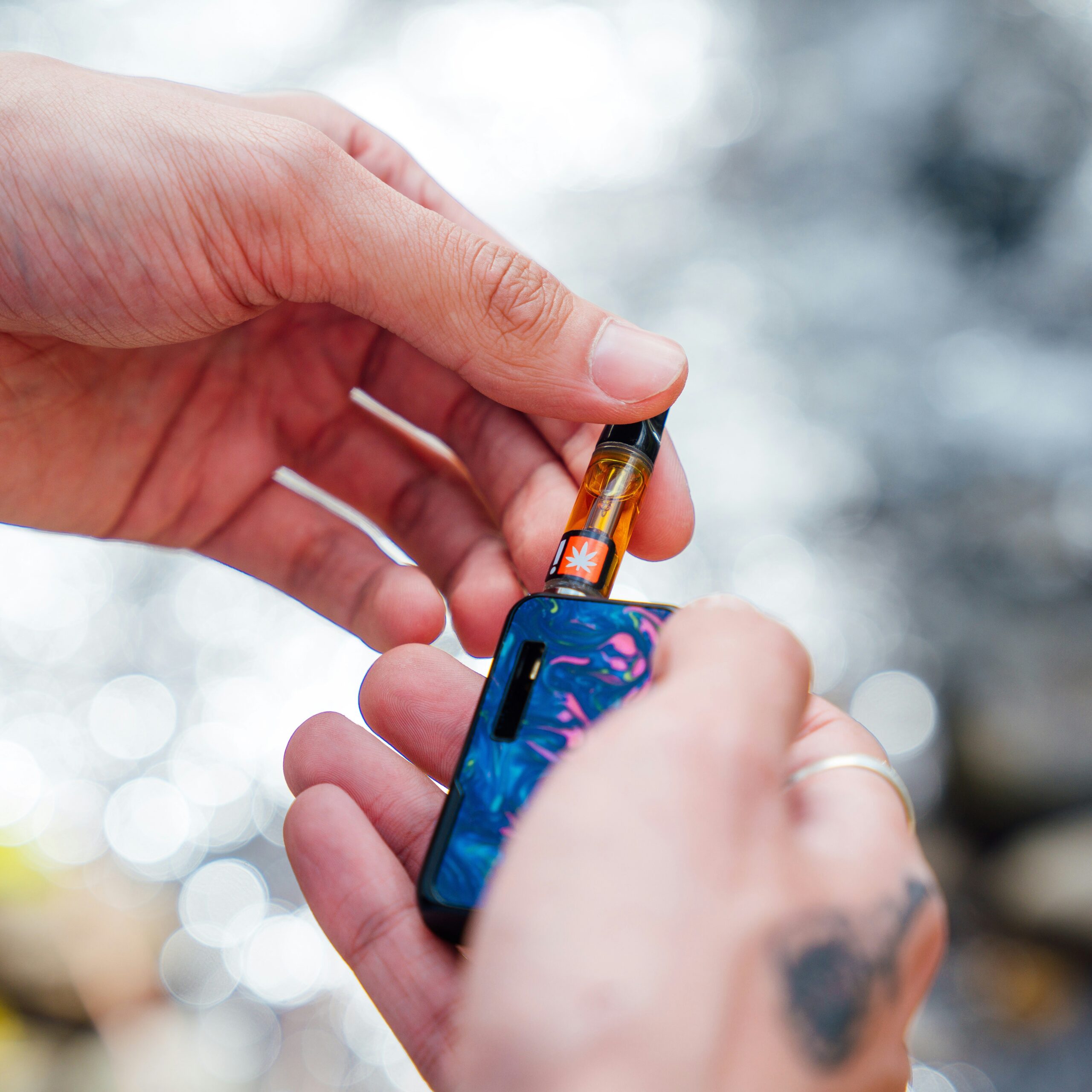 Hands holding a THC cartridge available through weed delivery