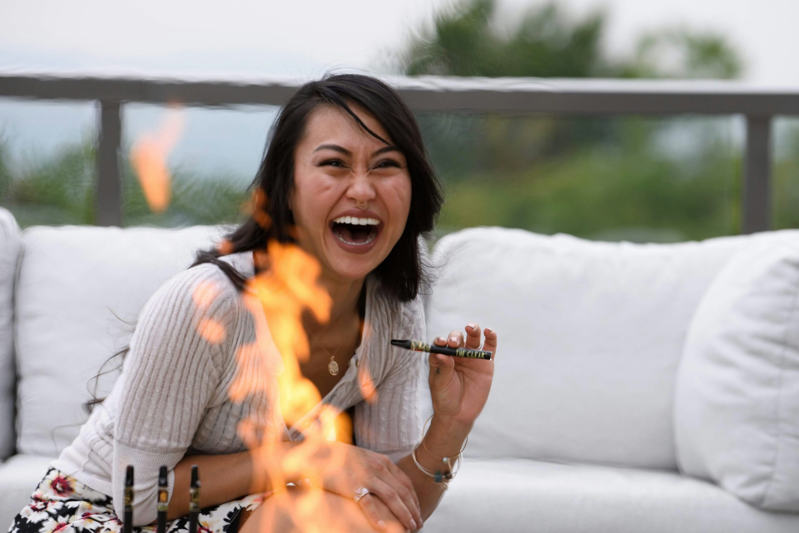 Woman laughing while holding a vape pen, enjoying weed delivery Edmonton