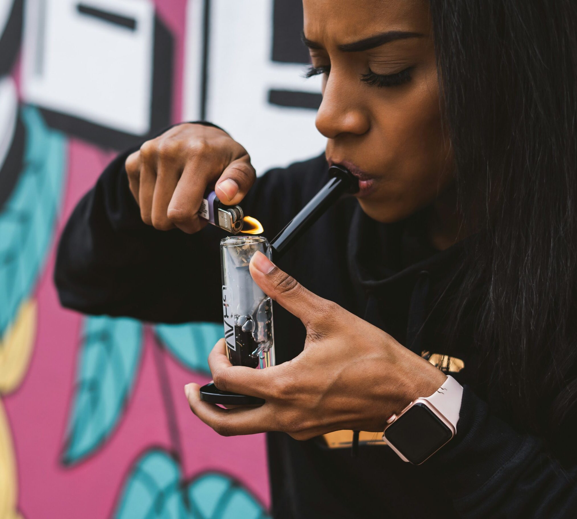 Woman lighting a cannabis pipe