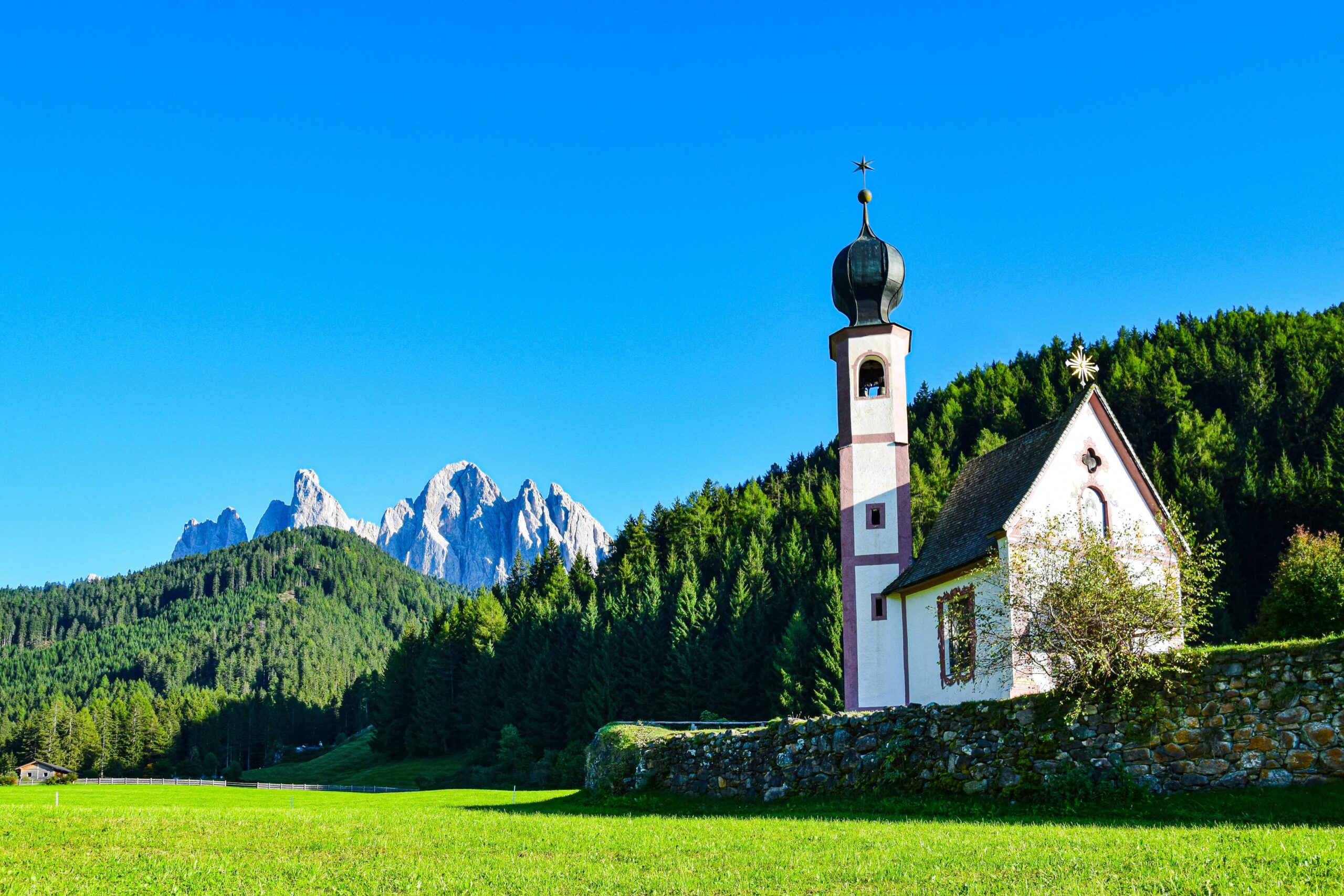 Scenic mountain view with a chapel in the foreground.