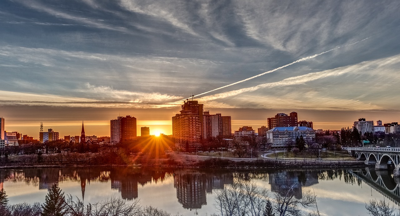 The cityscape of Regina, Saskatchewan, with modern buildings and autumn-colored trees in a park, highlighting cannabis delivery services.