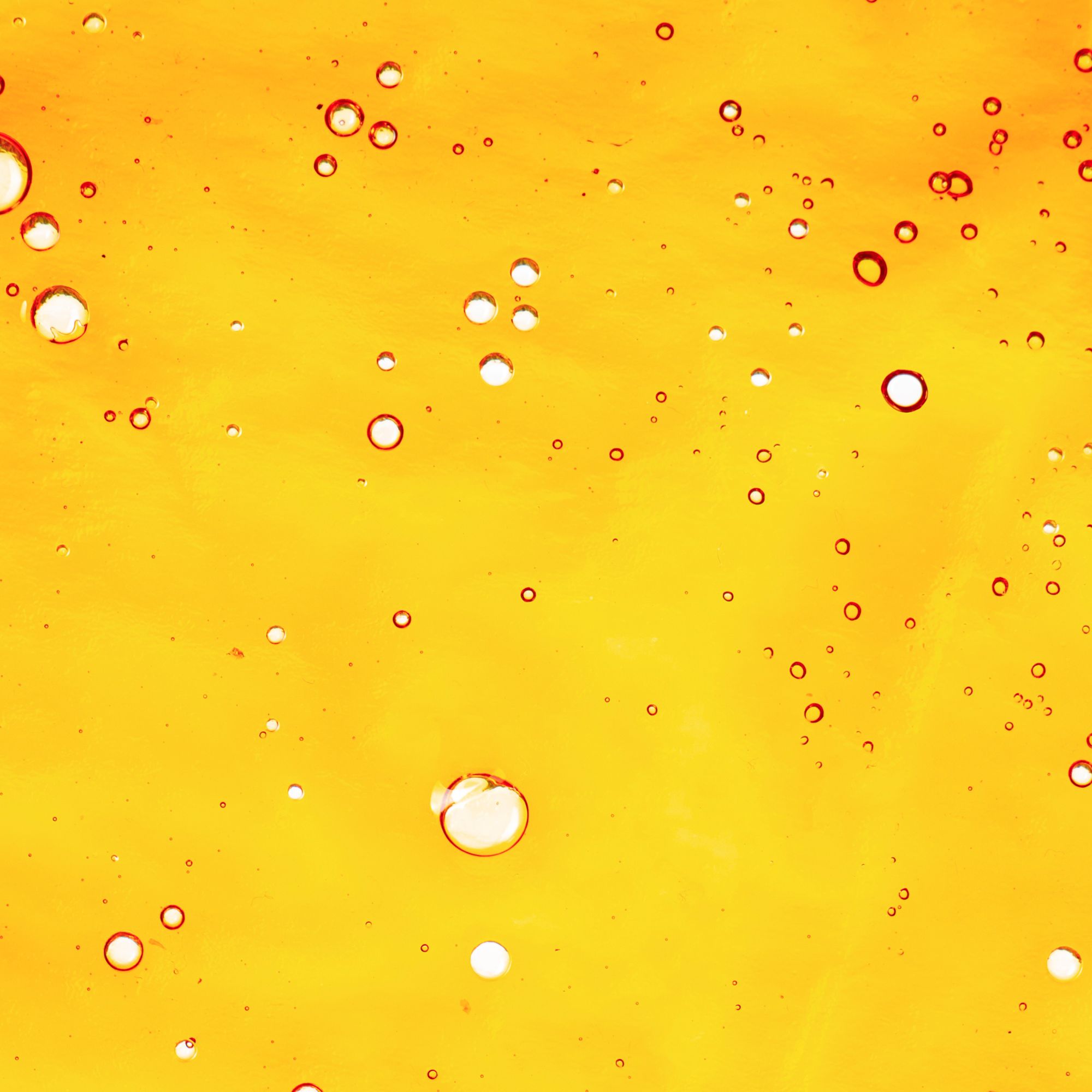 Macro shot of translucent cannabis shatter showing air bubbles.